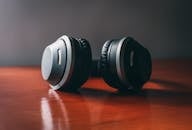 Close-up of sleek wireless headphones on a wooden surface, perfect for music enthusiasts.