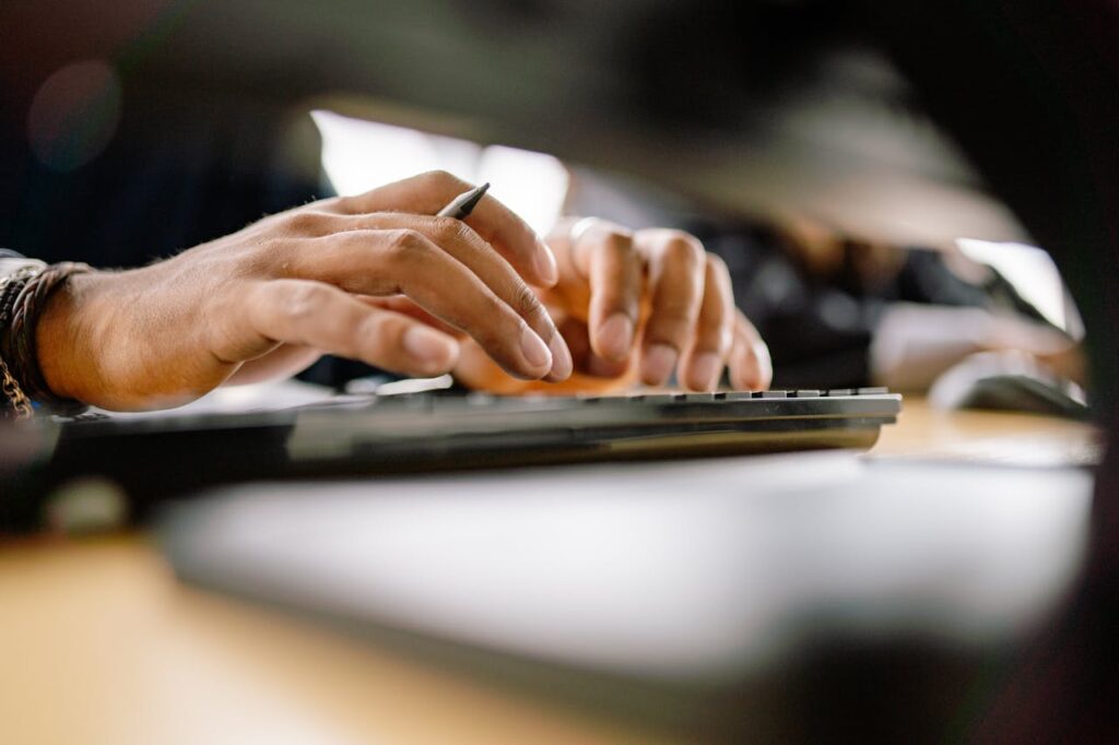 A detailed view of a person typing on a keyboard, emphasizing productivity and office work.